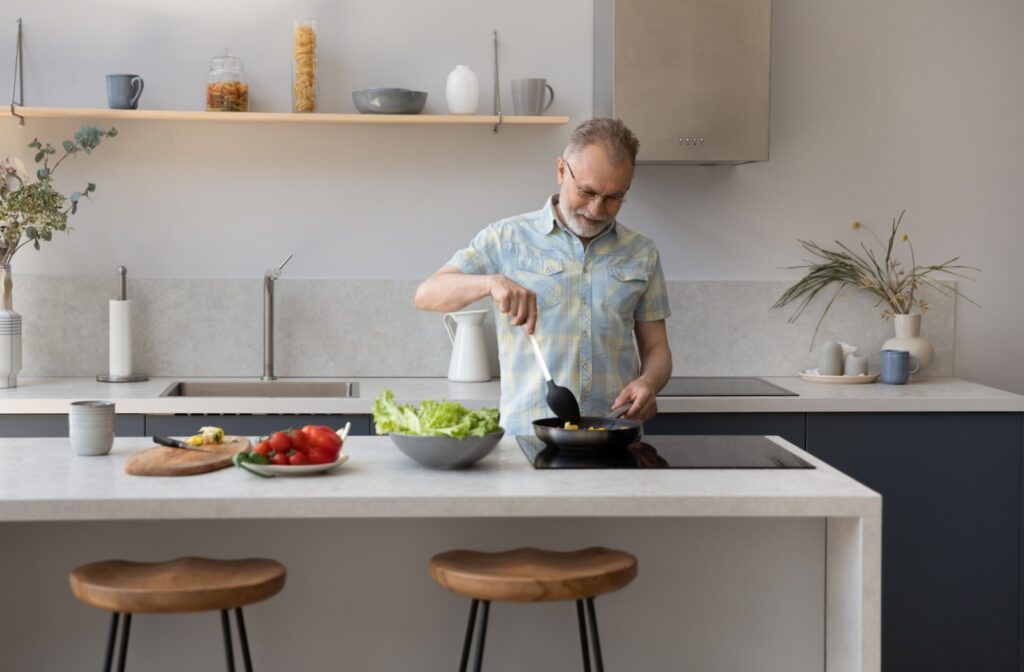 An older adult man meal prepping in his kitchen.