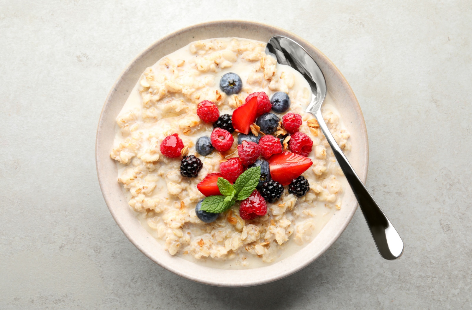 A healthy bowl of oatmeal with berries and cream.
