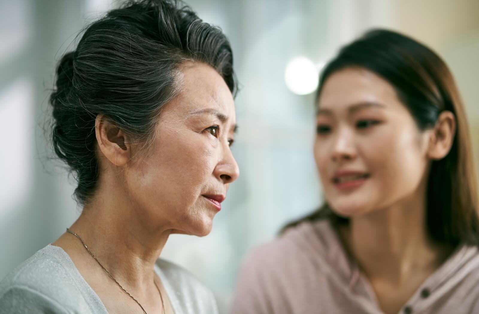 An adult child tries talking to their senior parent with dementia who doesn’t seem to hear them